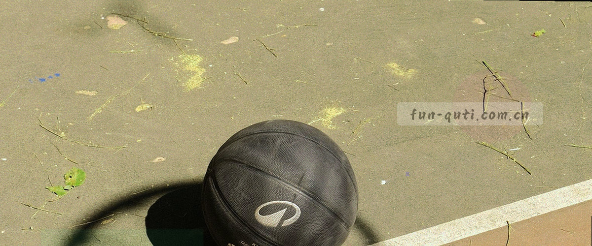 观众席虚化光斑，看台旗帜连成一片，暖黄色灯光铺满看台